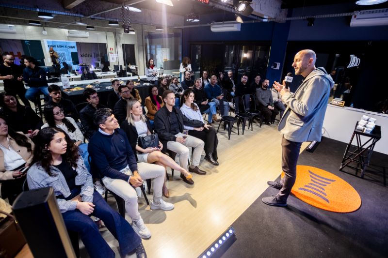 Professionals in a modern office engaged in corporate training with digital tablets and AI assistants on screens