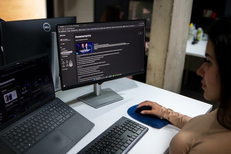 Team of diverse professionals collaborating using AI tools on laptops in modern office