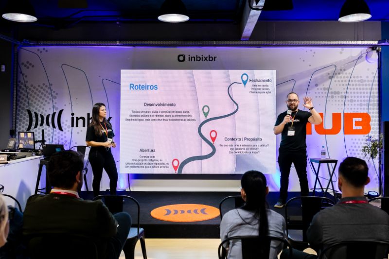 Equipe corporativa reunida em sala moderna discutindo metas e objetivos em quadro branco com gráficos e post-its coloridos