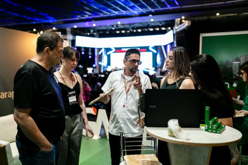 Grupo diversificado de profissionais discutindo em uma sala com gráficos e anotações coloridas.