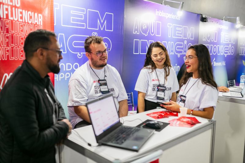 Equipe de trabalho reunida em mesa colaborativa com laptops e anotações