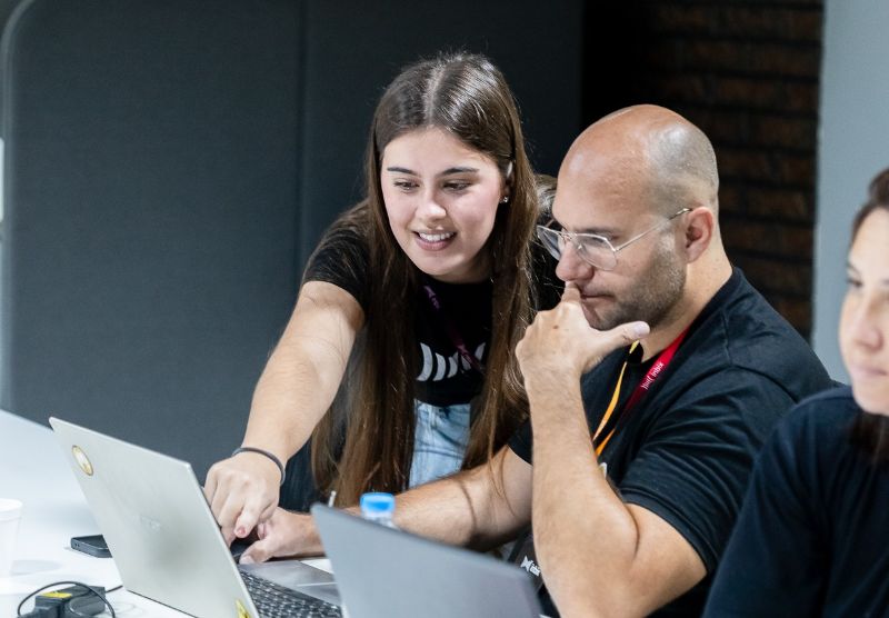 Teacher using AI tablet with students in a futuristic classroom surrounded by digital learning icons