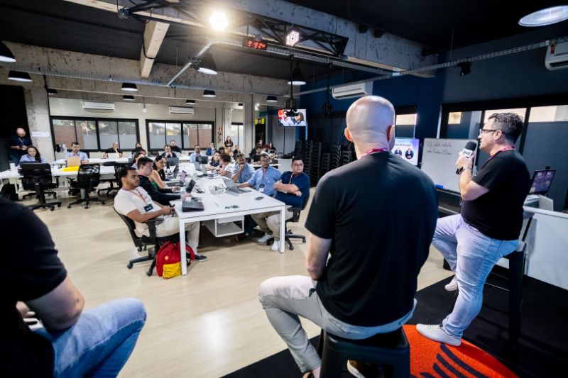 Equipe de profissionais reunida em ambiente corporativo moderno discutindo projetos e aprendizado