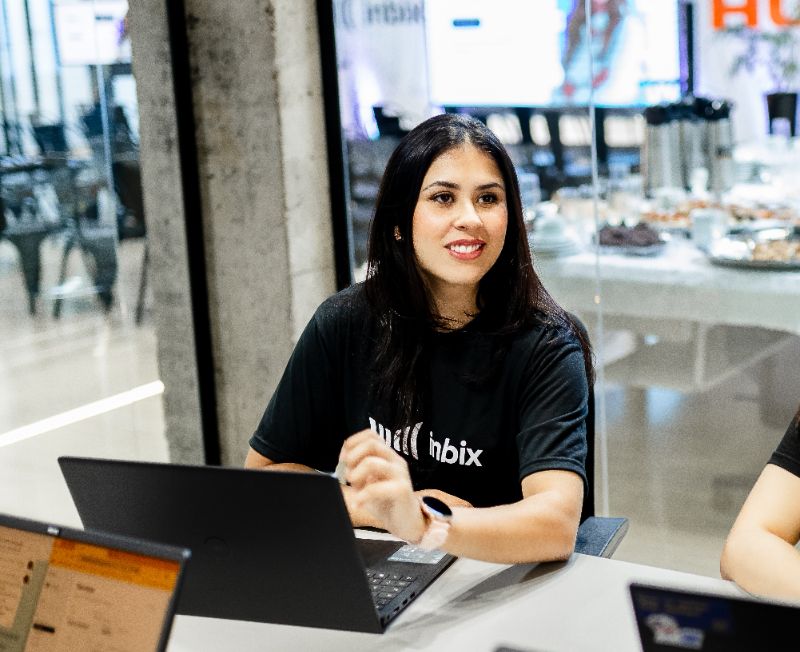 Funcionários em ambiente corporativo utilizando base de conhecimento digital para treinamento e onboarding rápido