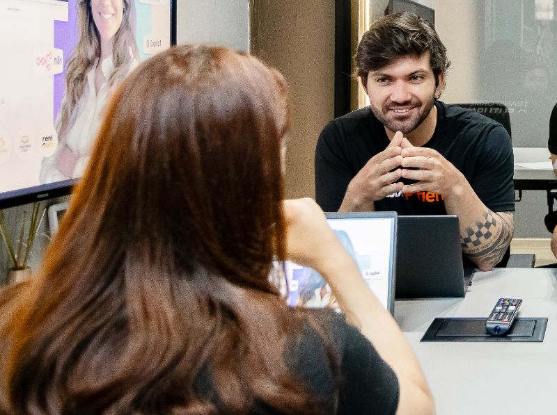 Pessoa usando laptop com tela exibindo interface de criação de quizzes com IA e gráficos de desempenho ao redor