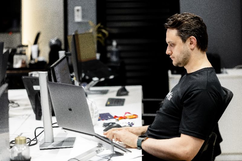 Profissional revisando e atualizando conteúdos digitais de treinamento com gráficos e listas de controle auditável em tela de computador