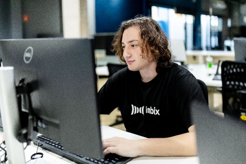 Pessoa interagindo com plataforma digital exibindo módulos de microcertificação corporativa em tela de computador moderno