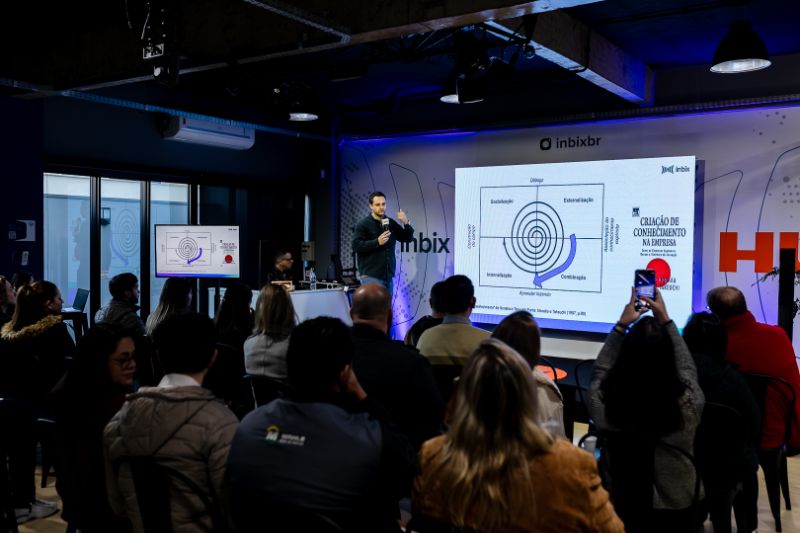 Equipe corporativa diversificada participando de treinamento digital em sala moderna com laptops e tablets