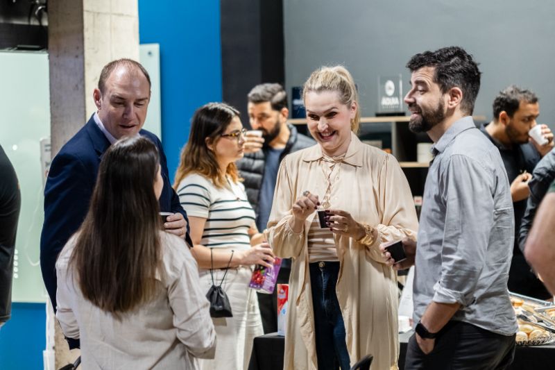 Equipe diversa colaborando em um escritório moderno, focada em inovação e experiência do cliente, com gráficos e feedback.