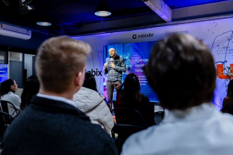 Equipe corporativa em reunião colaborativa com laptops e tablet, discutindo bases contextuais para onboarding ágil