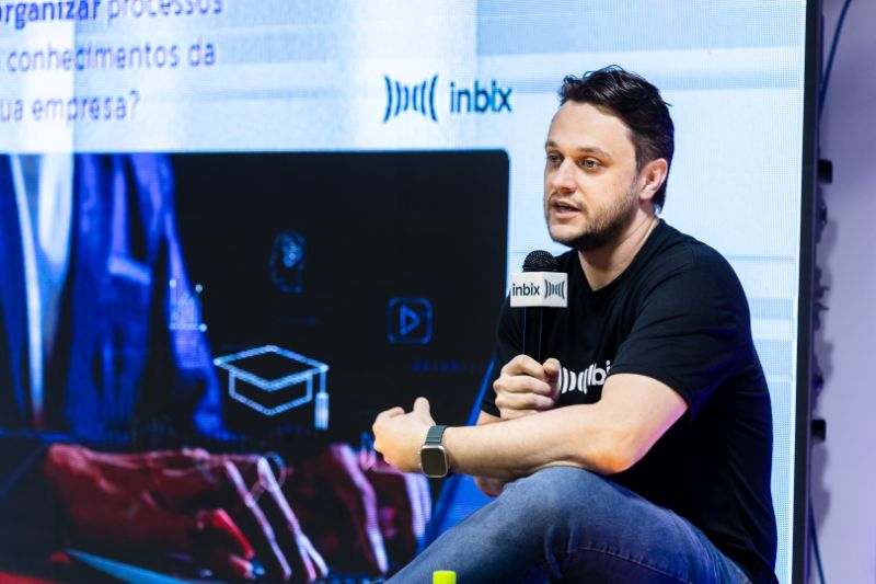 Equipe de colaboradores em ambiente corporativo interagindo com plataformas digitais de aprendizado assistidas por inteligência artificial