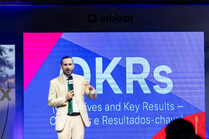 Dashboard de LMS com gráficos de OKRs, trilhas e indicadores de compliance visíveis na tela do computador