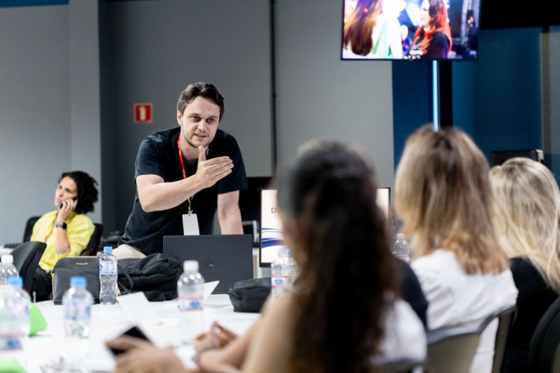 Colaboradores em ambiente de trabalho remoto com computadores e reuniões virtuais exibindo dificuldades de engajamento