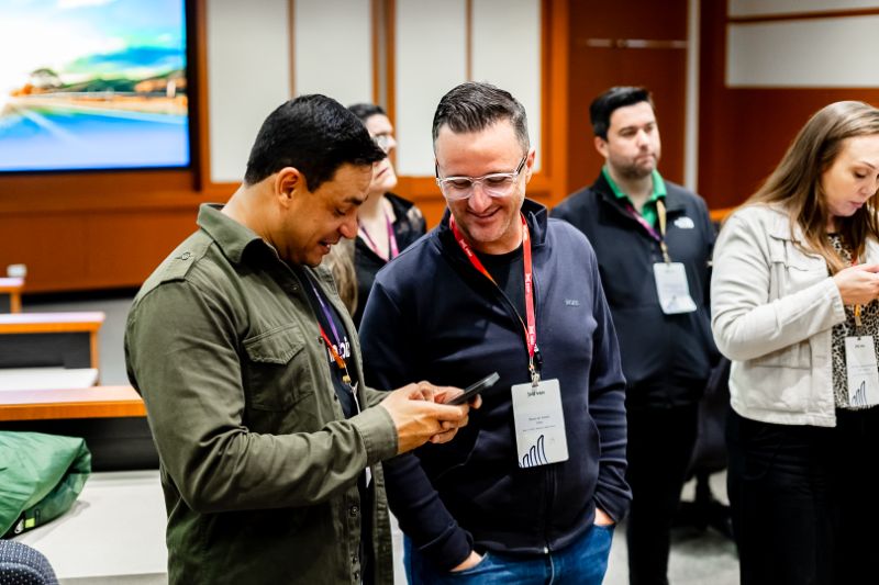 Colaboradores interagindo com conteúdo digital de treinamento em tablets durante o onboarding