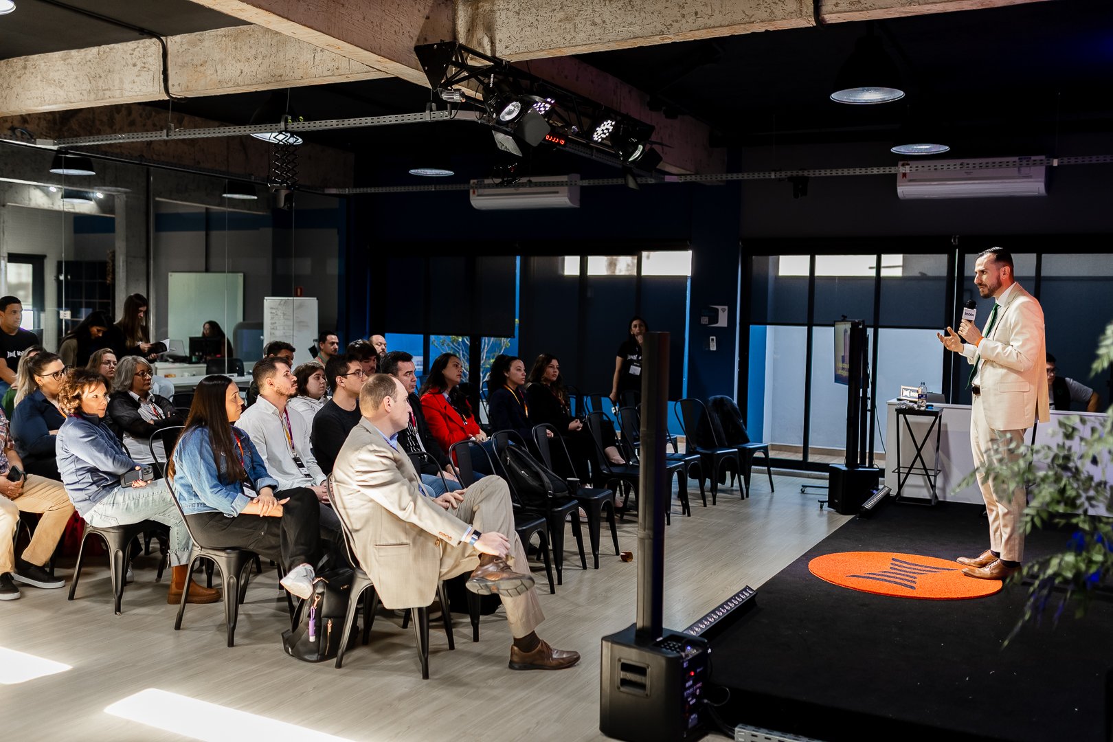 Gestor com painel de treinamento gamificado em tela grande para parceiros