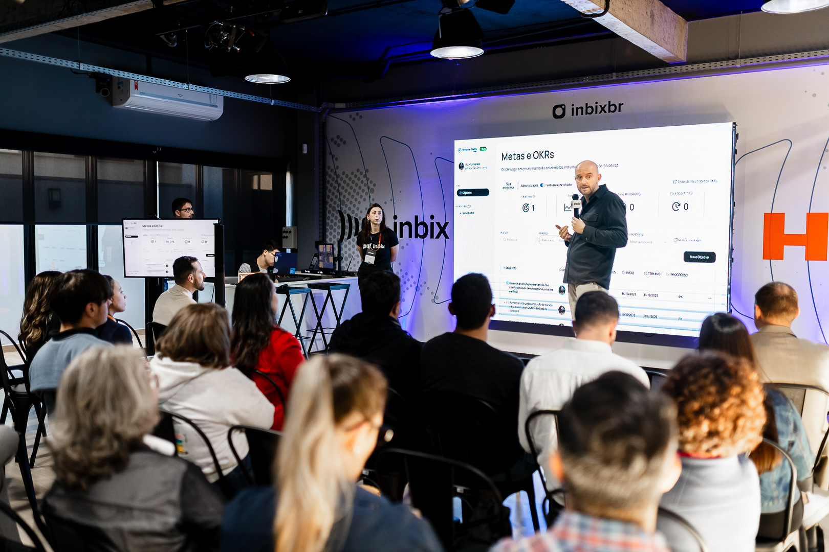 Gestores analisando trilha de aprendizagem de compliance em painel digital