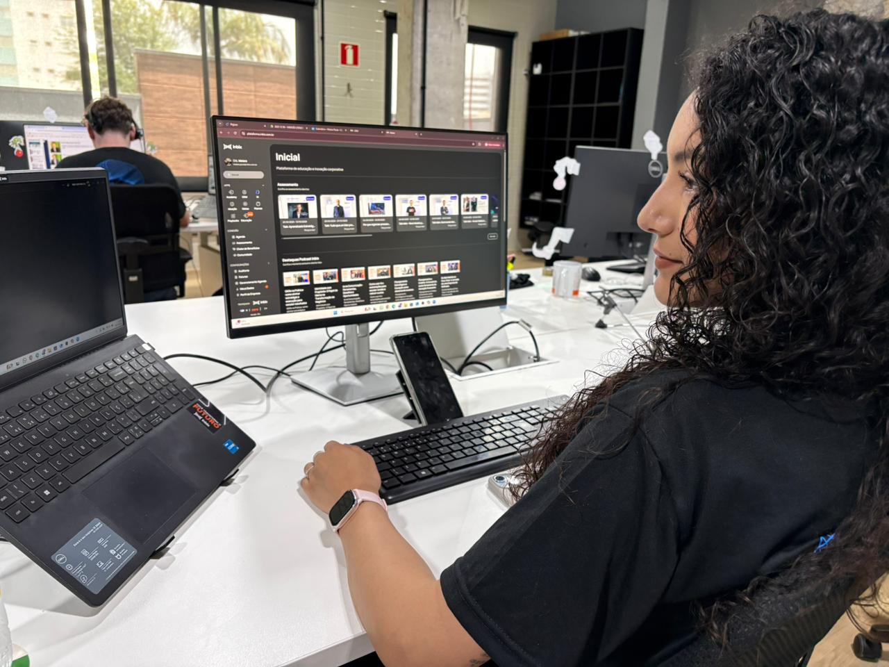 Gestor analisando painel de trilhas de treinamento no computador com gráficos e alertas de obsolescência