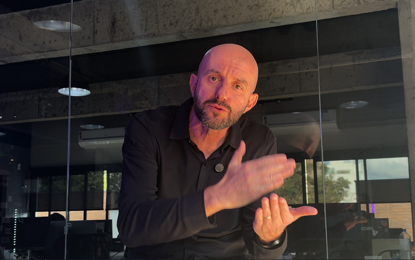 Consultor de performance orientando líder e colaboradora diante de painel com metas