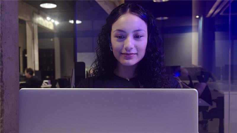 Equipe em mesa redonda planejando implementação de programa corporativo em tela grande